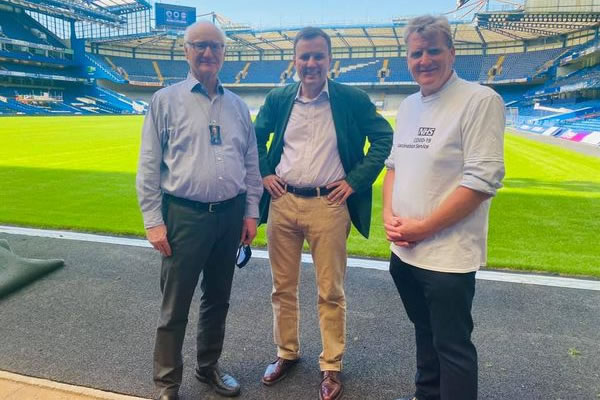 Greg Hands at a vaccination event at Stamford Bridge last year wiith Chairman Bruce Buck and NW London NHS head Julian Redhead