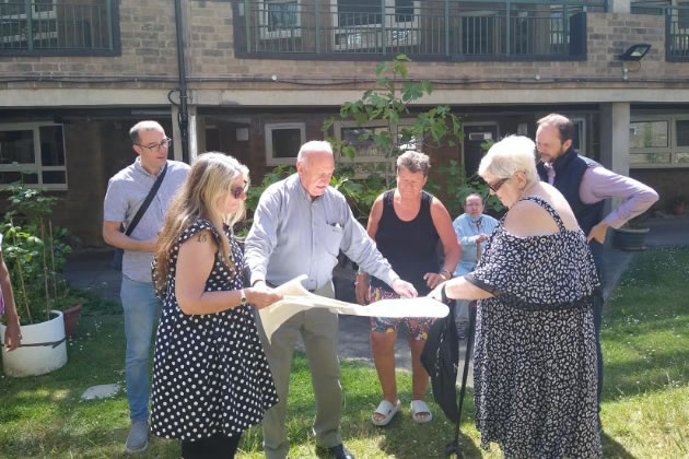 Adriaan Van Zyl (centre, holding plans) working with residents and council officers